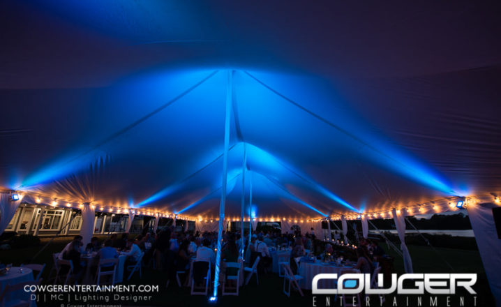 colorfully lit tent over crowded wedding reception