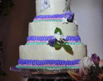 spolight illumitates multi-tiered wedding cake on table